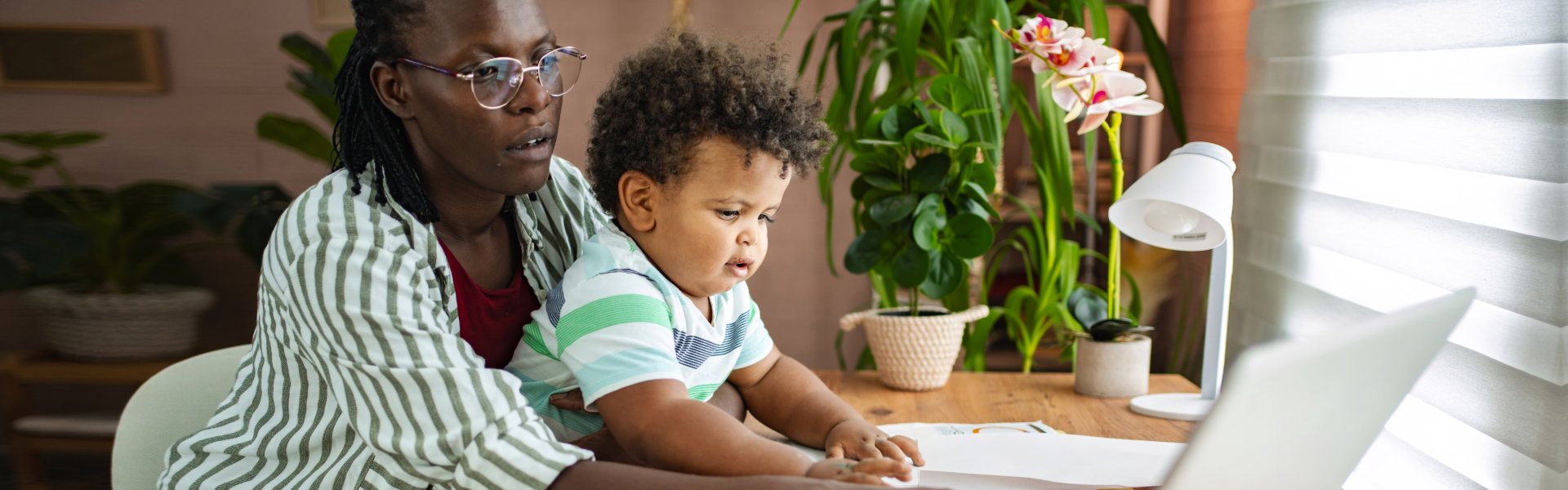 mother and child working together on a laptop in a cozy home office